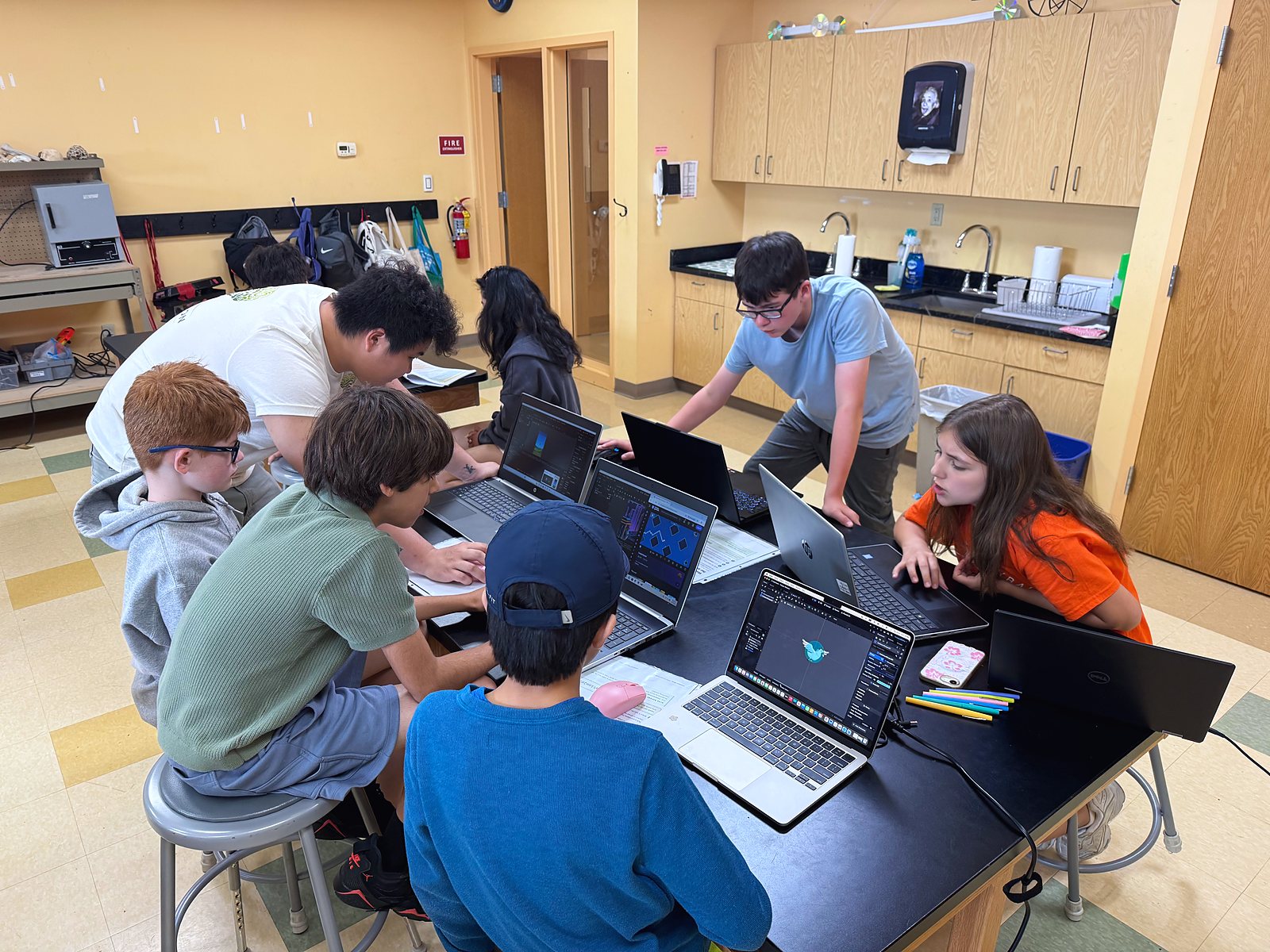 Students at laptops building their games during Game Time