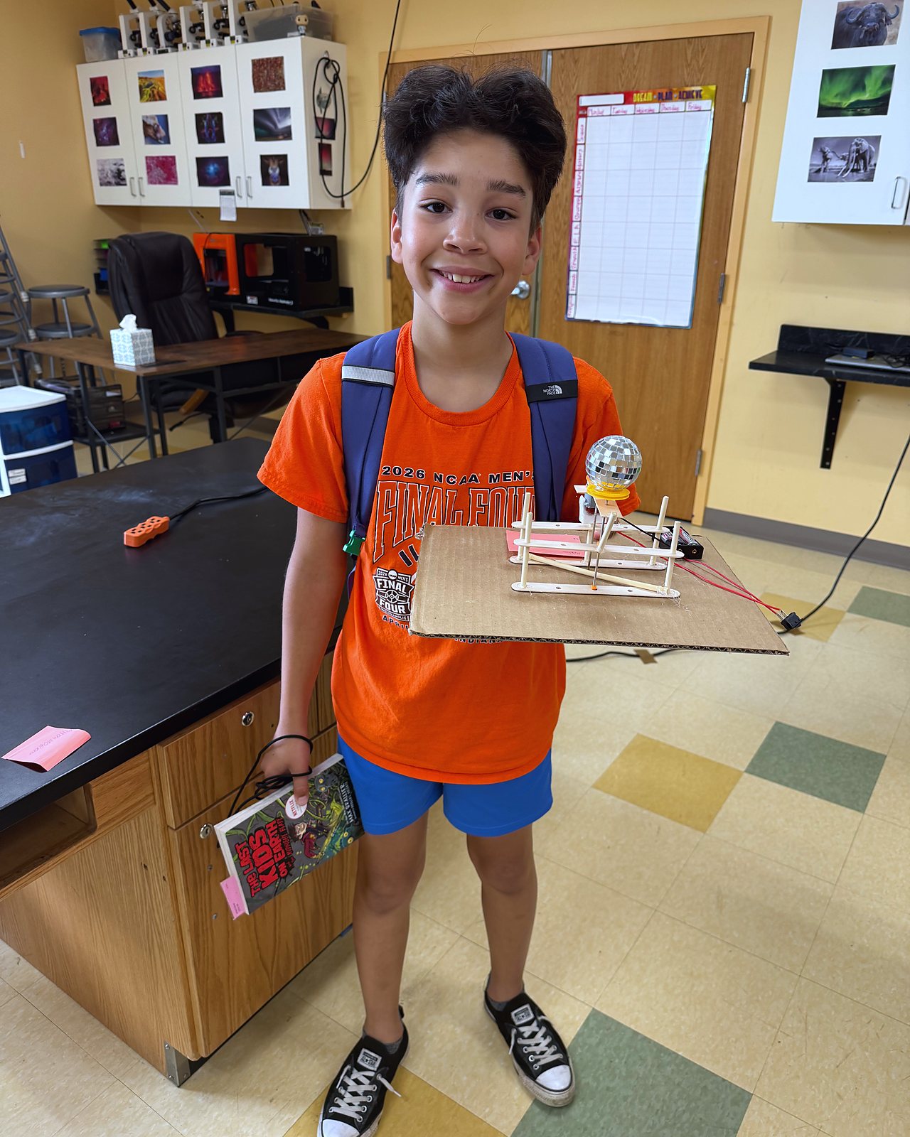 A student holds up the mirror ball rig he built to save the Discodome